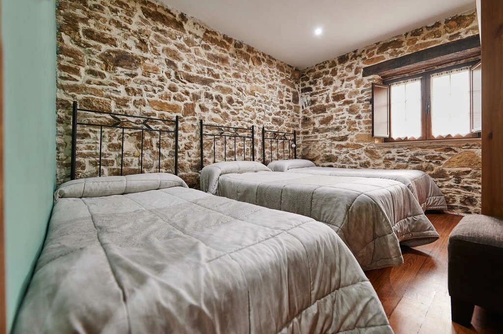 Habitación con paredes de piedra · Casa Madreselva