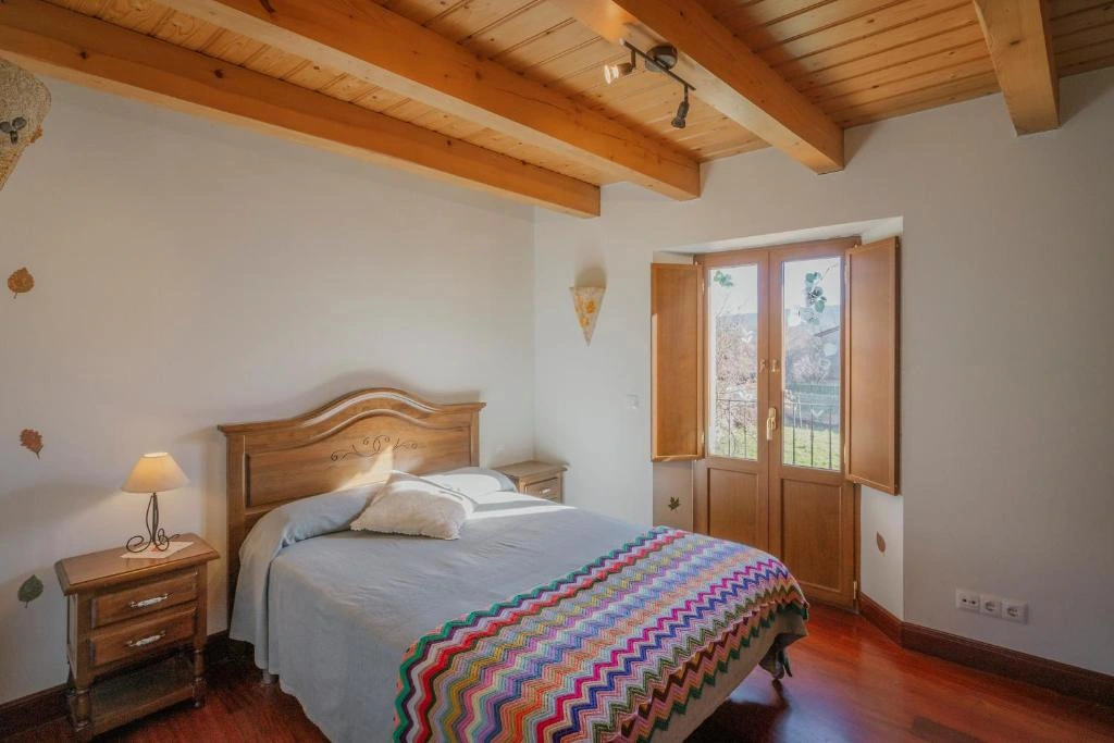 Dormitorio con balcón de Casa Rural La Cabaña, Agüera