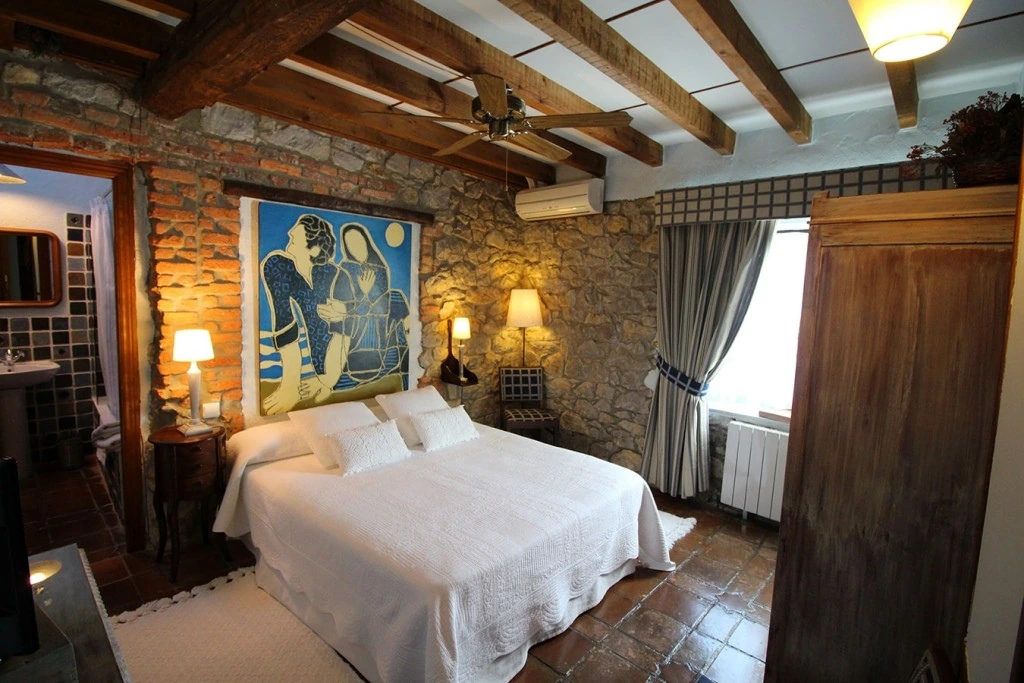 Habitación con paredes de piedra · Posada La Llosa