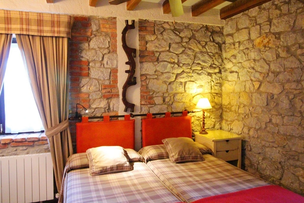 Habitación bajo vigas de madera · Posada La Llosa