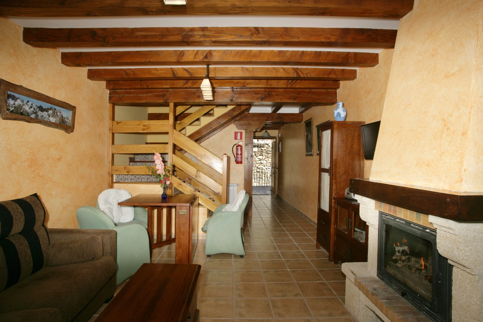 Sala con chimenea y escalera · Viviendas Rurales Peña Sagra