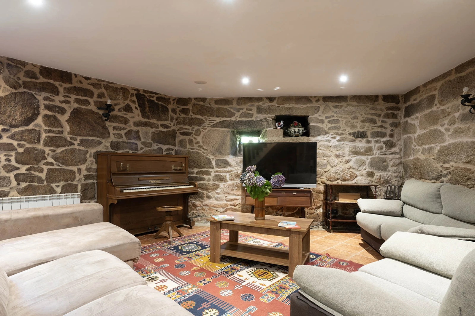 Sala de estar con paredes de piedra · Casa Manteiga