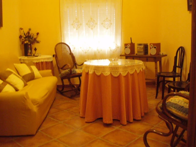 Sala de estar con mesa junto a la ventana de Casa Angustias en Rioja