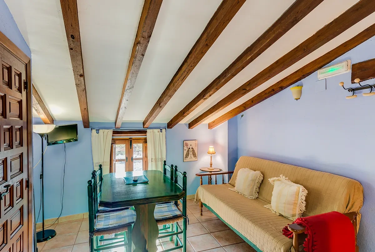 Salón con vigas de madera de un apartamento de Casa Manadero · Apartamentos Rurales Casa Manadero