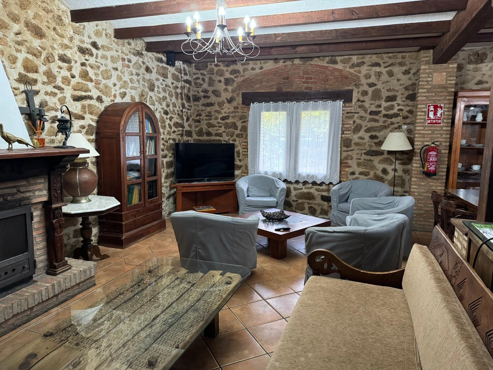 Salón de La Casona con chimenea y paredes de piedra · Complejo Rural La Casona de Jaraíz