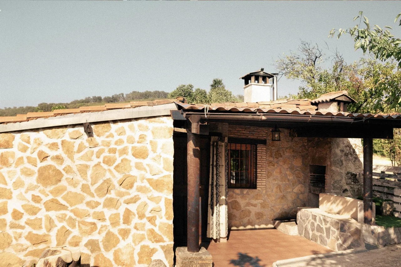 Fachada y porche de la casa de piedra · Mirador Los Cotos