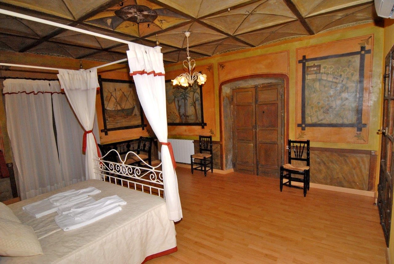 Dormitorio con cama de dosel y pinturas murales · Casa Rural Sietevillas