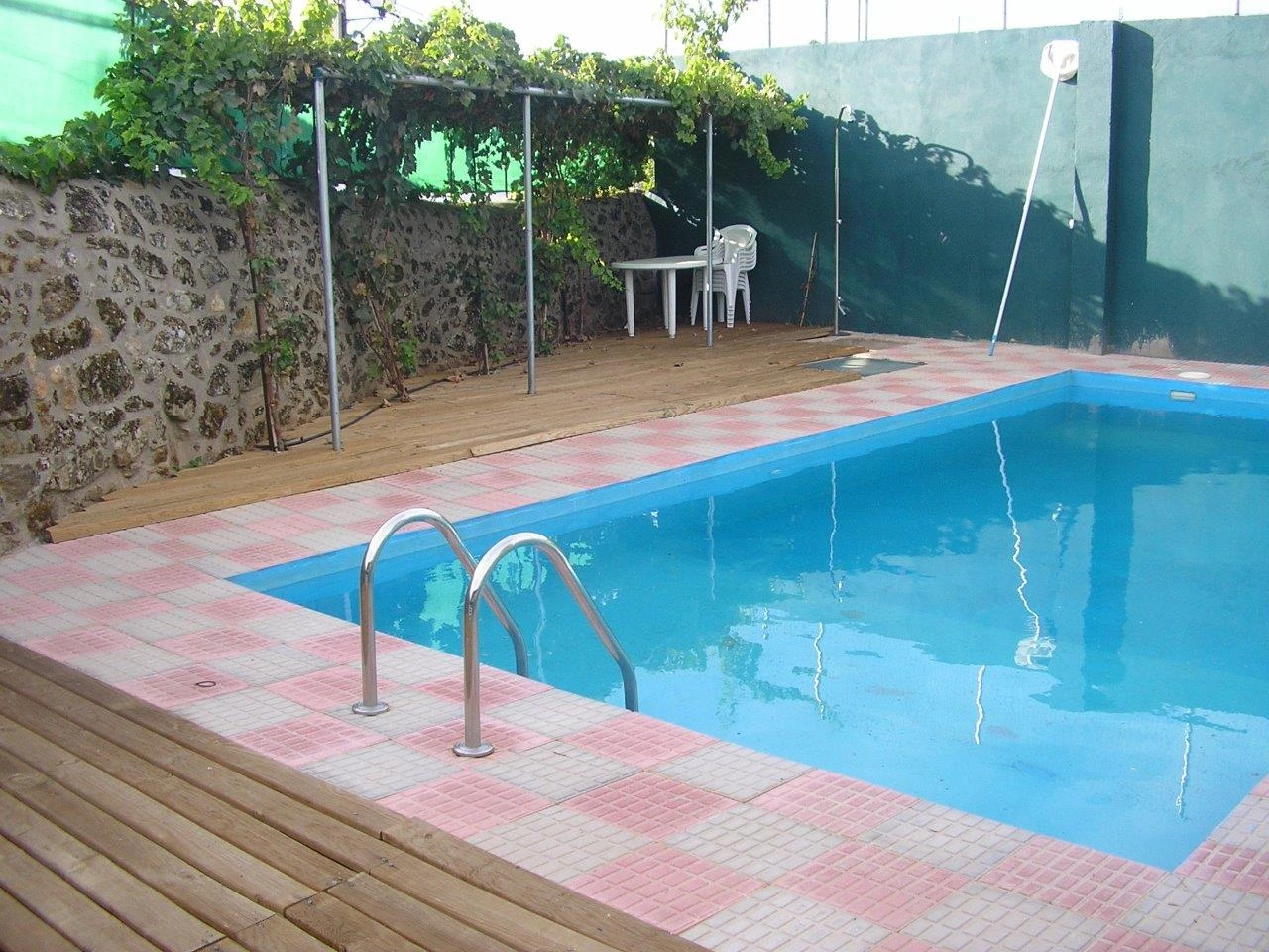 Piscina y zona de sombra junto al jardín · Casa Rural Sietevillas