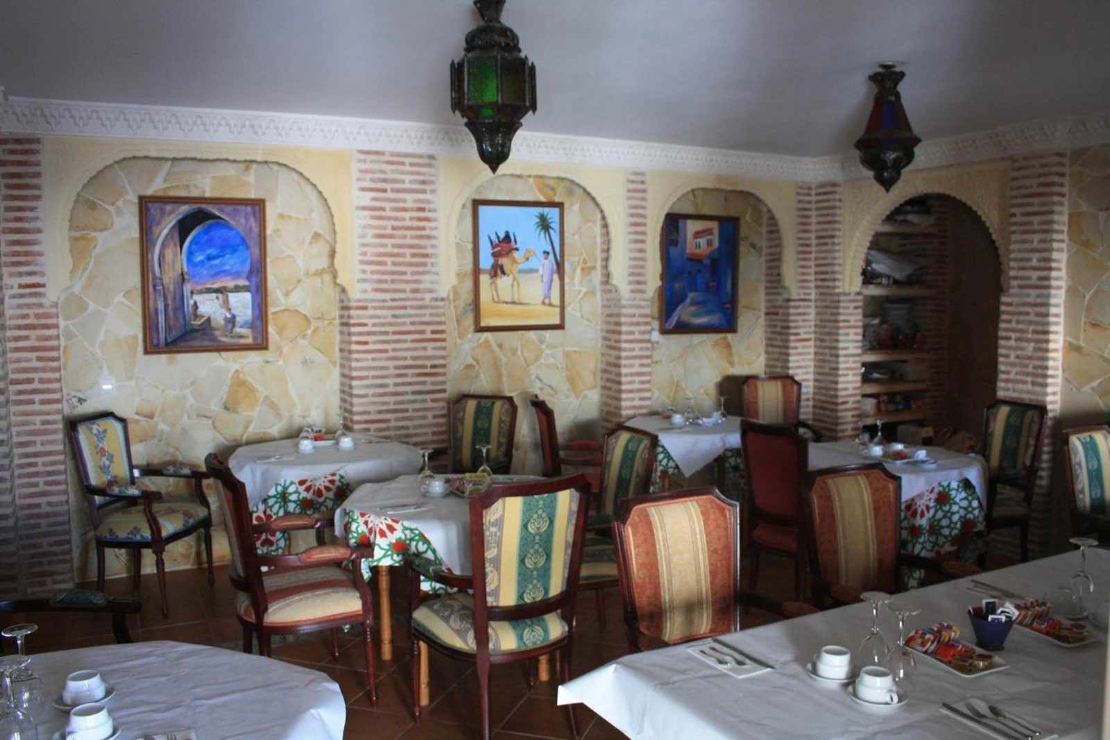 Salón comedor de Casa Rural Sidonia con mesas y decoración de piedra · Casa Rural Sidonia