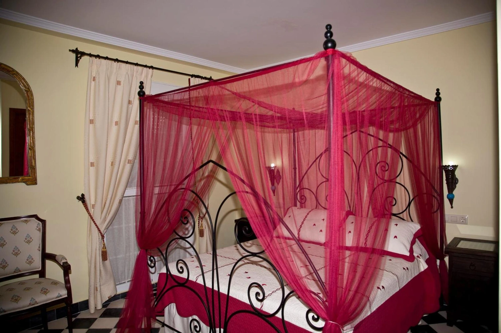 Dormitorio de Casa Rural Sidonia con cama de baldaquino rojo · Casa Rural Sidonia