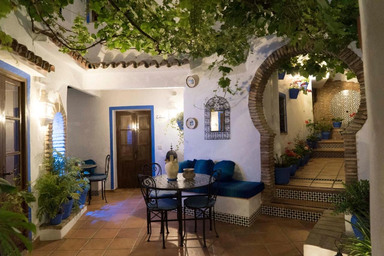 Patio central de El Cobijo de Vejer con parra, arco de ladrillo y fuente · El Cobijo de Vejer