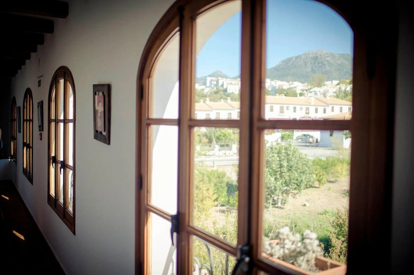 Pasillo del hotel con ventanas arqueadas y vistas de El Bosque · Hotel Rural Enrique Calvillo