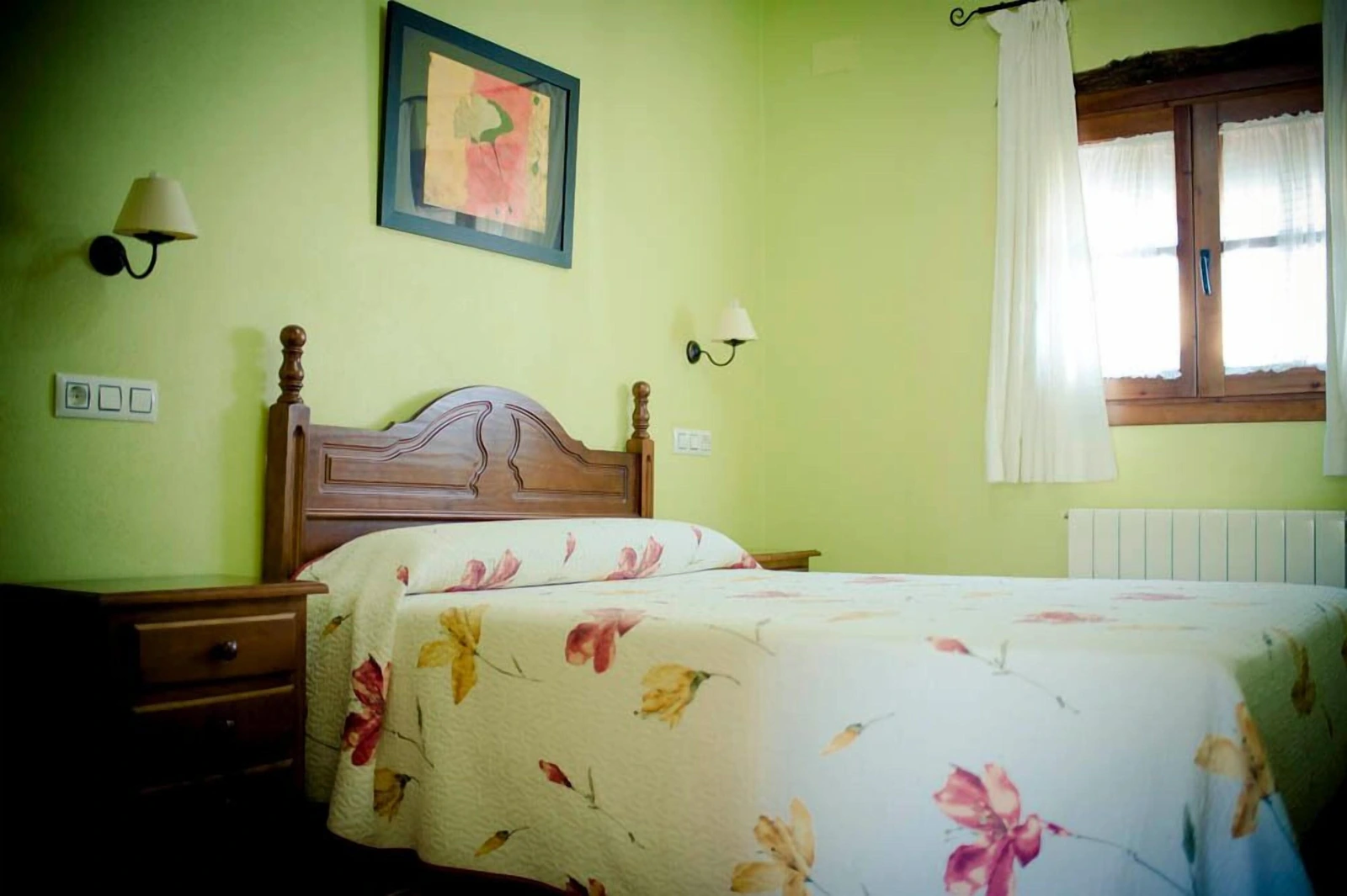 Habitación doble del hotel con paredes verdes y colcha floral · Hotel Rural Enrique Calvillo