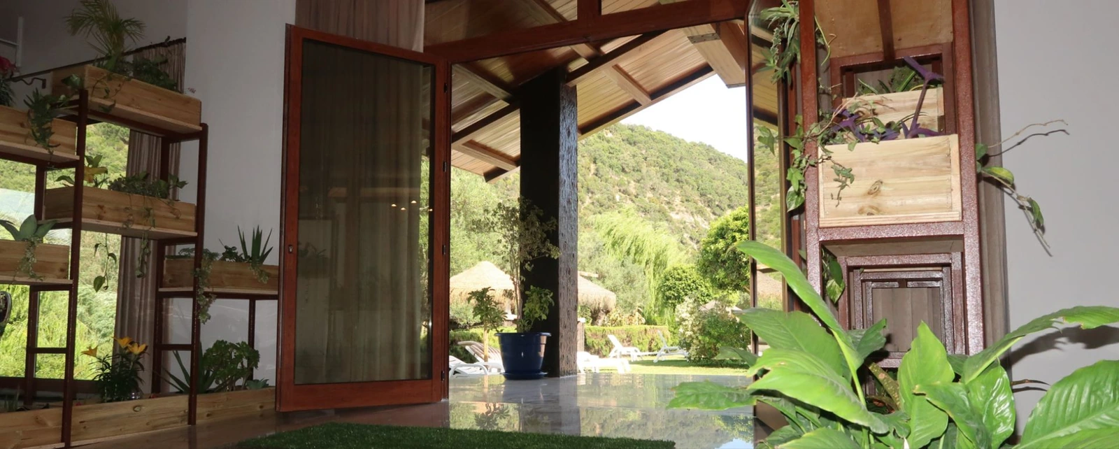 Vestíbulo acristalado del Hotel El Paso y salida al jardín · Hotel El Paso