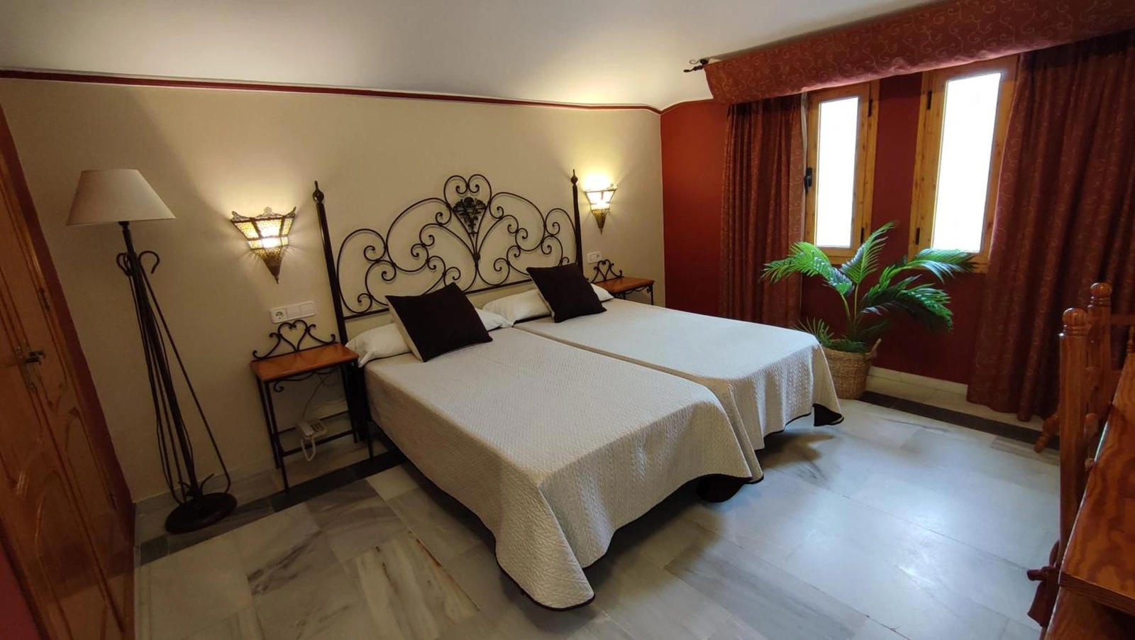 Habitación del Hotel El Paso con dos camas y cabecero de hierro · Hotel El Paso