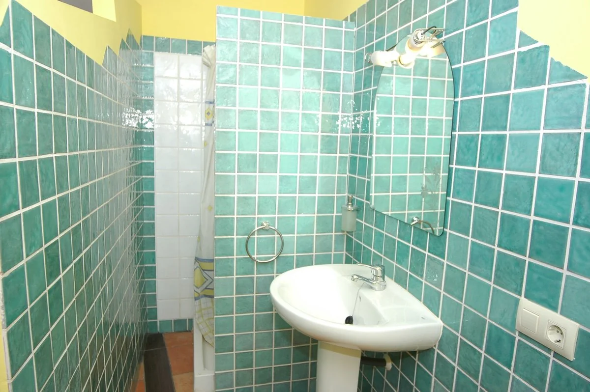 Baño con ducha de azulejos verdes · Casa Camí Real