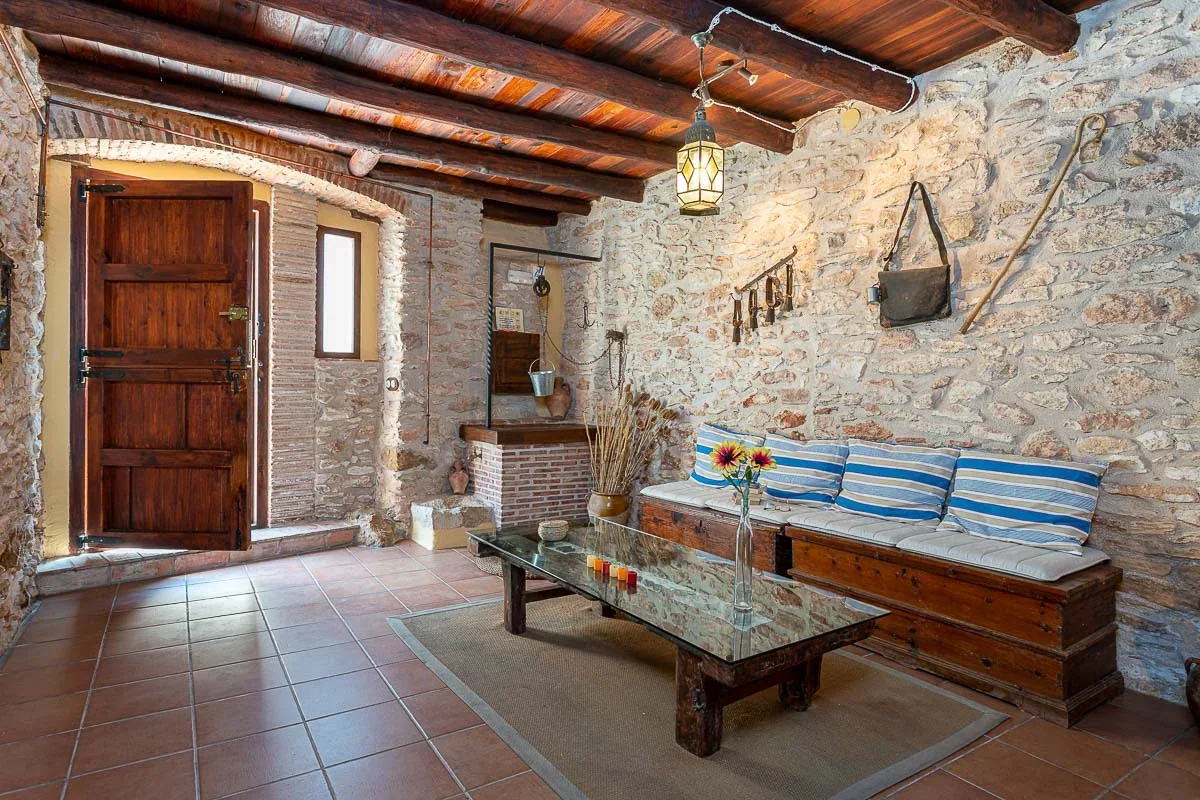 Sala de entrada con muros de piedra · Casa La Rafela