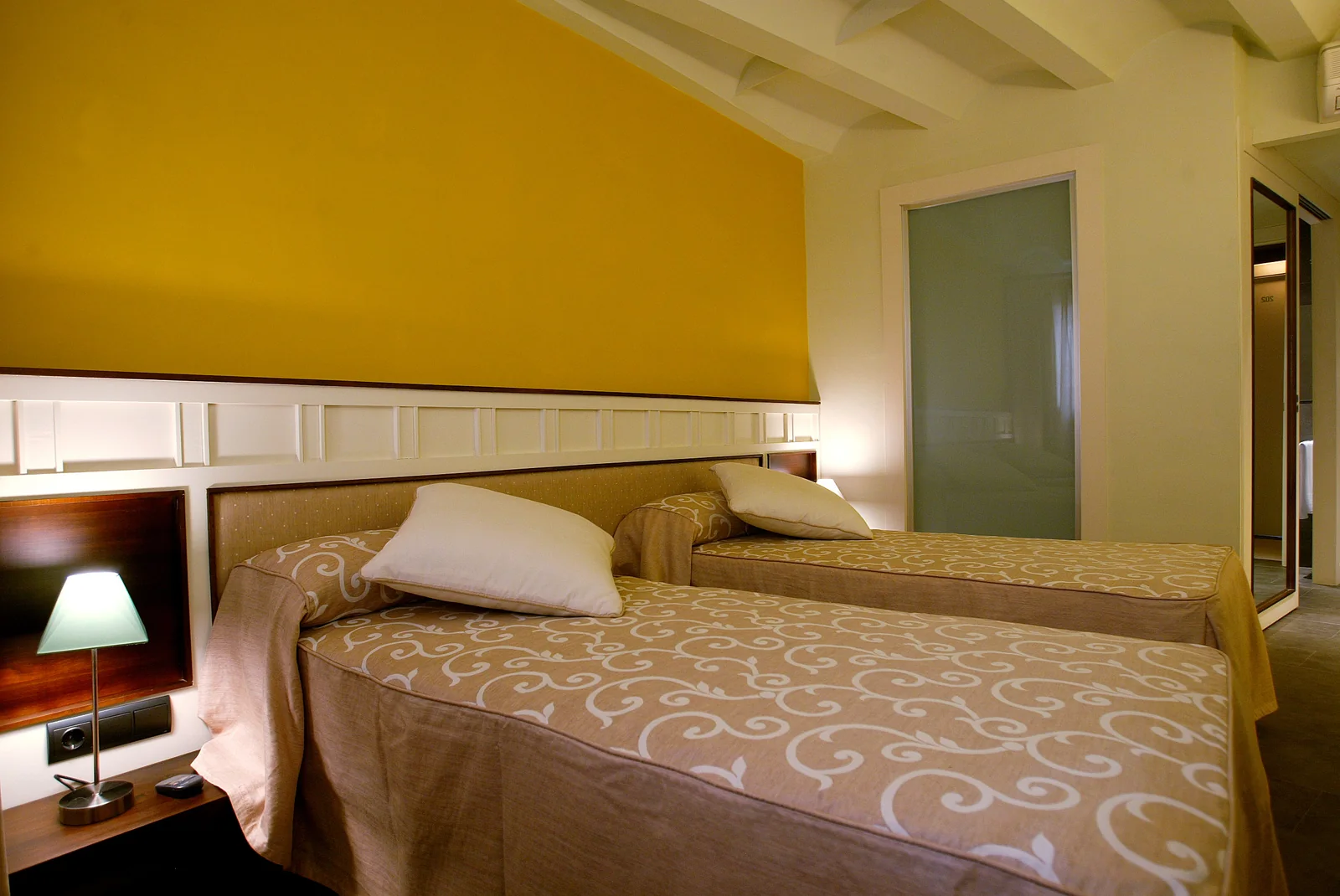 Habitación con pared ocre de La Fonda Moreno