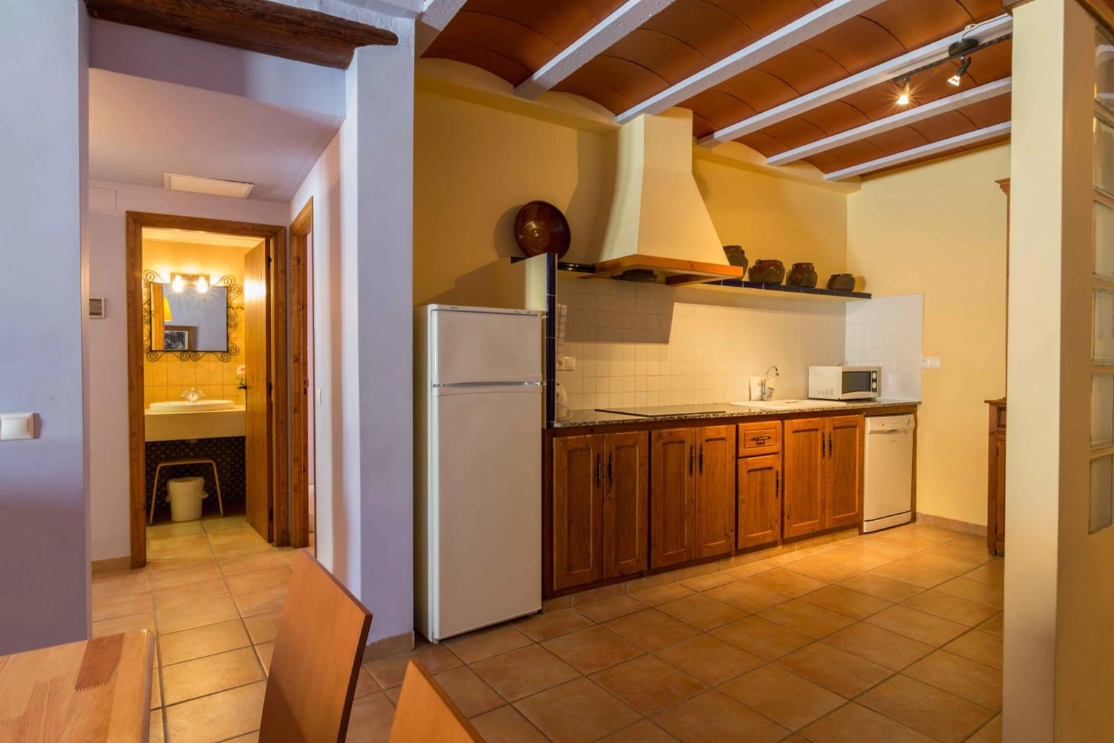 Cocina equipada junto a un pasillo con acceso al baño. · Mas dels Estellers