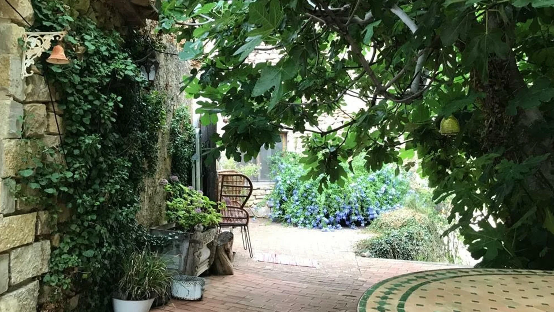 Patio de entrada bajo árboles · Masía Sort de Boix