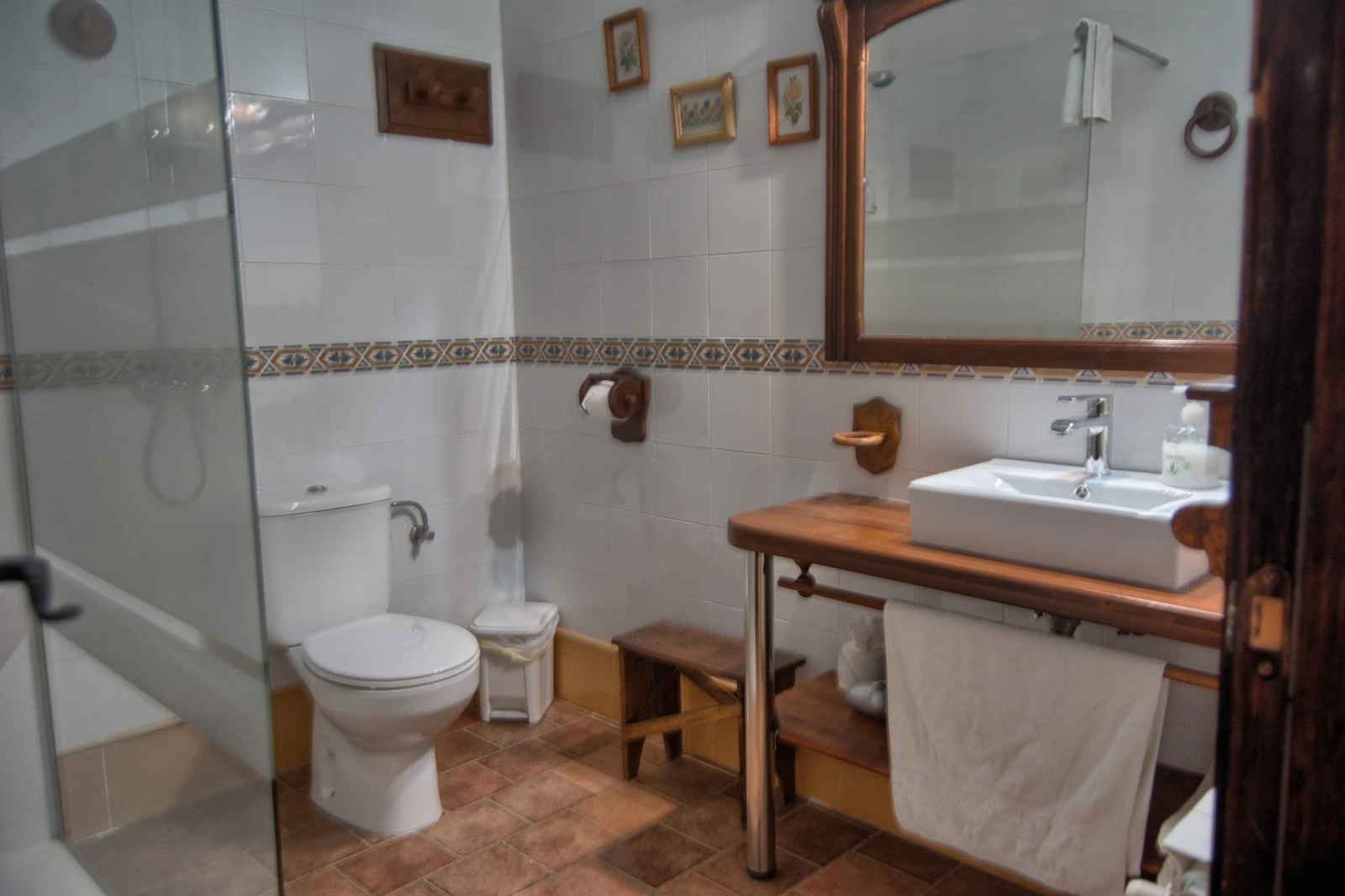 Baño de habitación doble con ducha y lavabo sobre madera · Posada Abuela Fidela