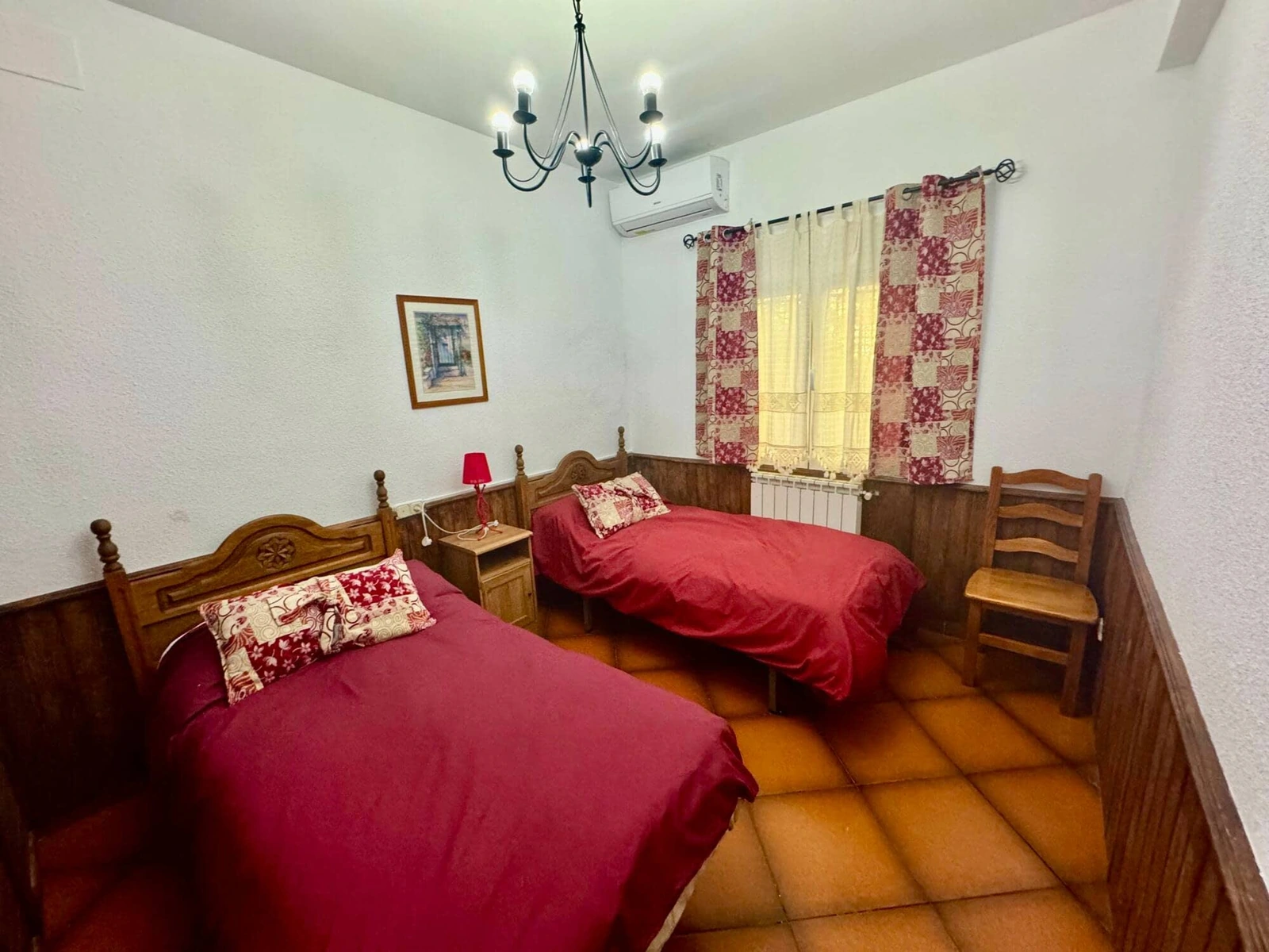 Dormitorio con dos camas y colchas rojas de Casa Los Jabones 1 · Casa Rural Los Jabones