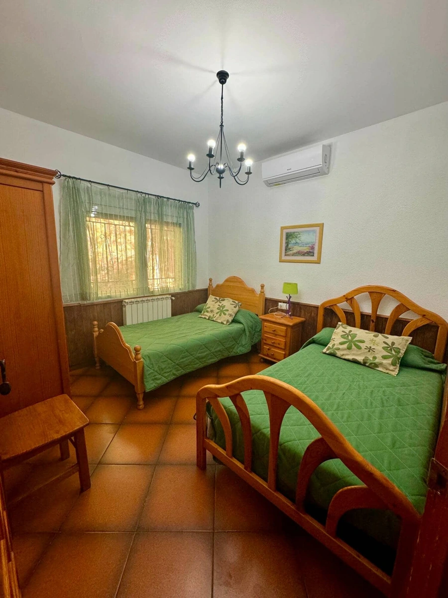 Dormitorio con dos camas y colchas verdes de Casa Los Jabones 1 · Casa Rural Los Jabones