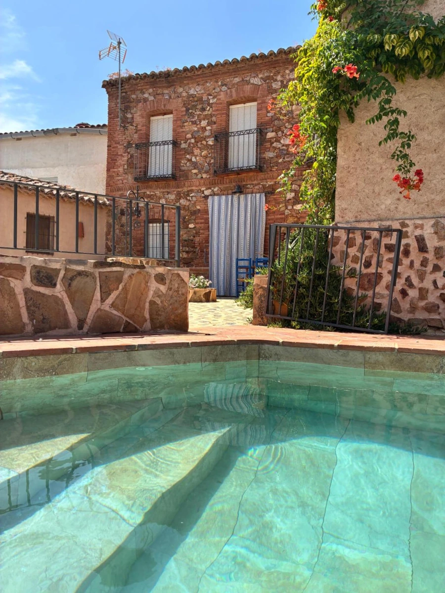 Piscina privada de La Cerquilla del Médico y edificio del alojamiento. · La Cerquilla del Médico