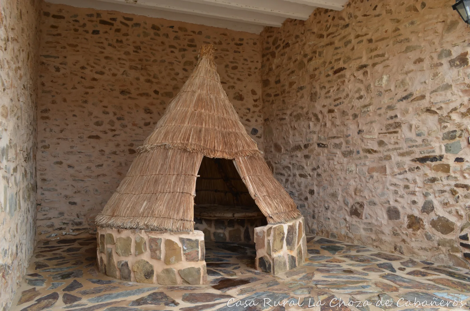 Chozo tradicional de pastores en el patio de piedra · La Choza de Cabañeros