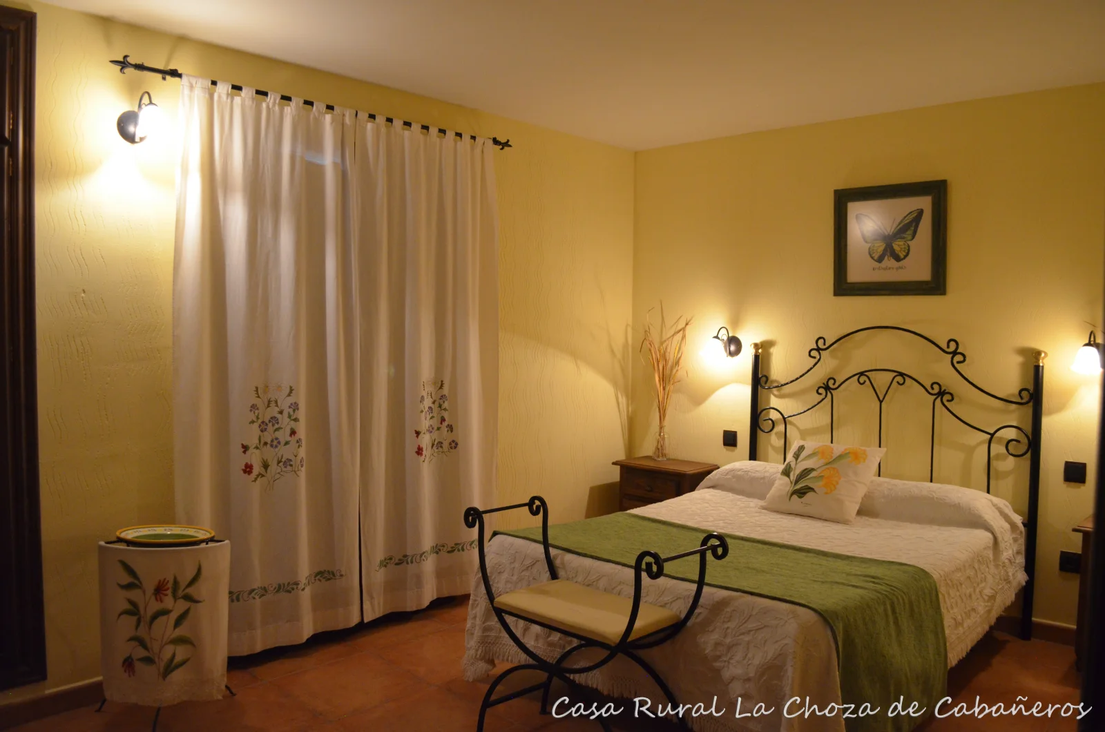 Dormitorio doble con cama de matrimonio y cabecero de forja · La Choza de Cabañeros