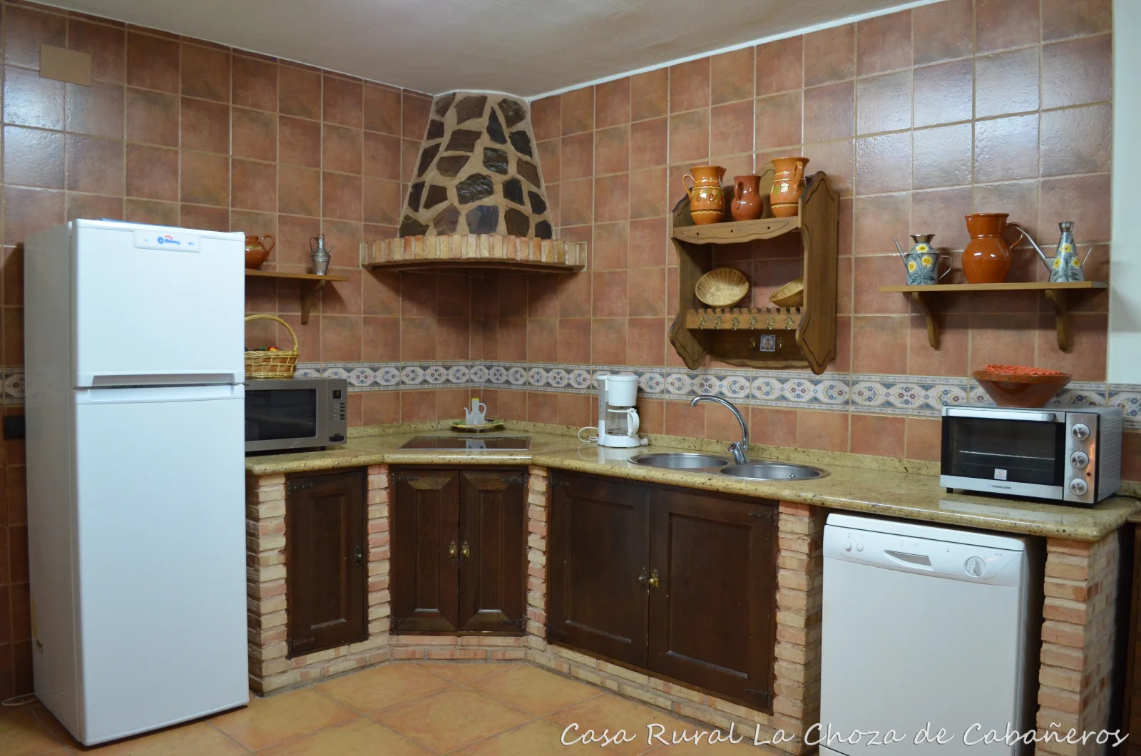 Cocina campera con electrodomésticos y mesa de comedor · La Choza de Cabañeros