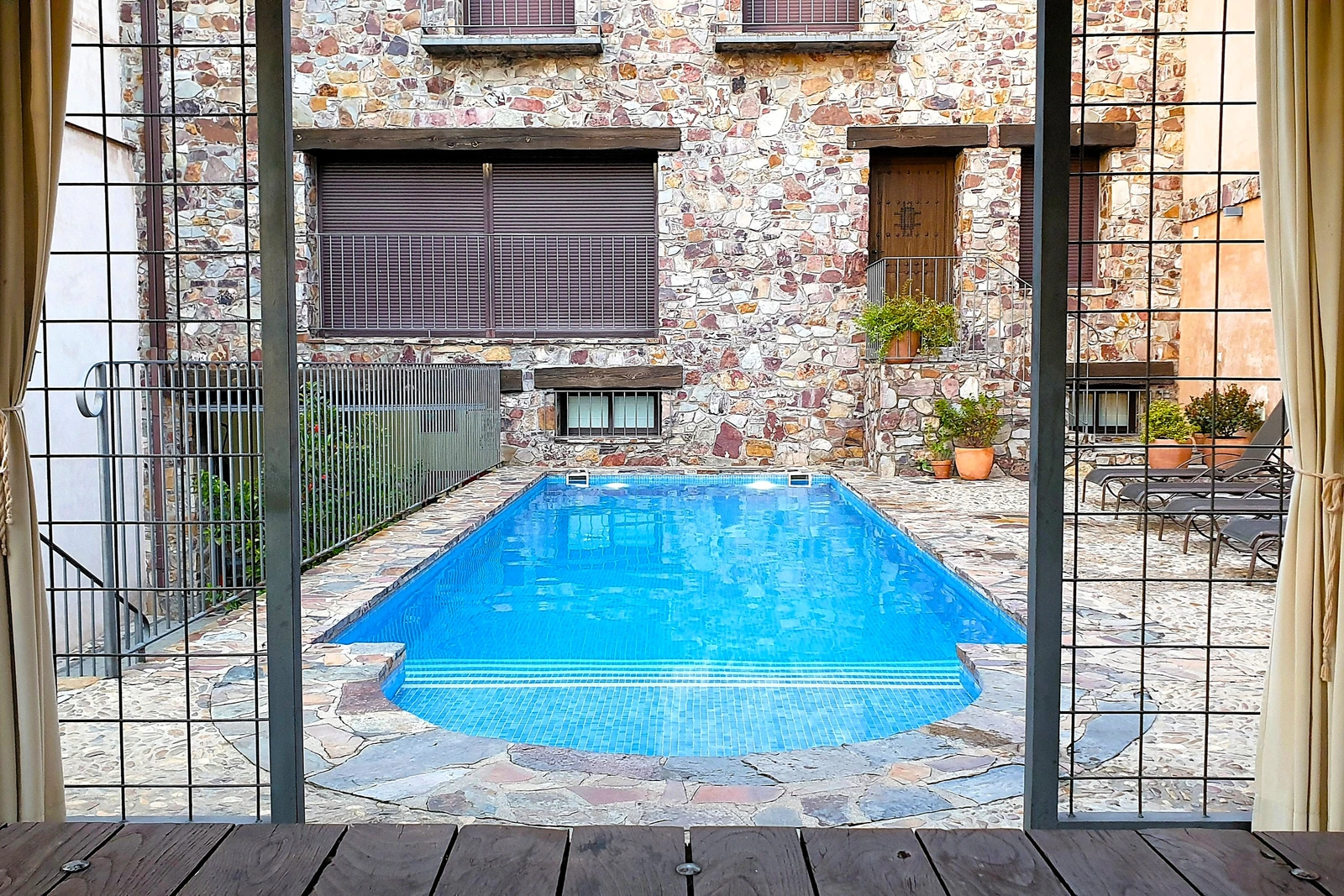 Piscina y fachada trasera vistas desde el cenador · Casa Rural La Fuente Gorda