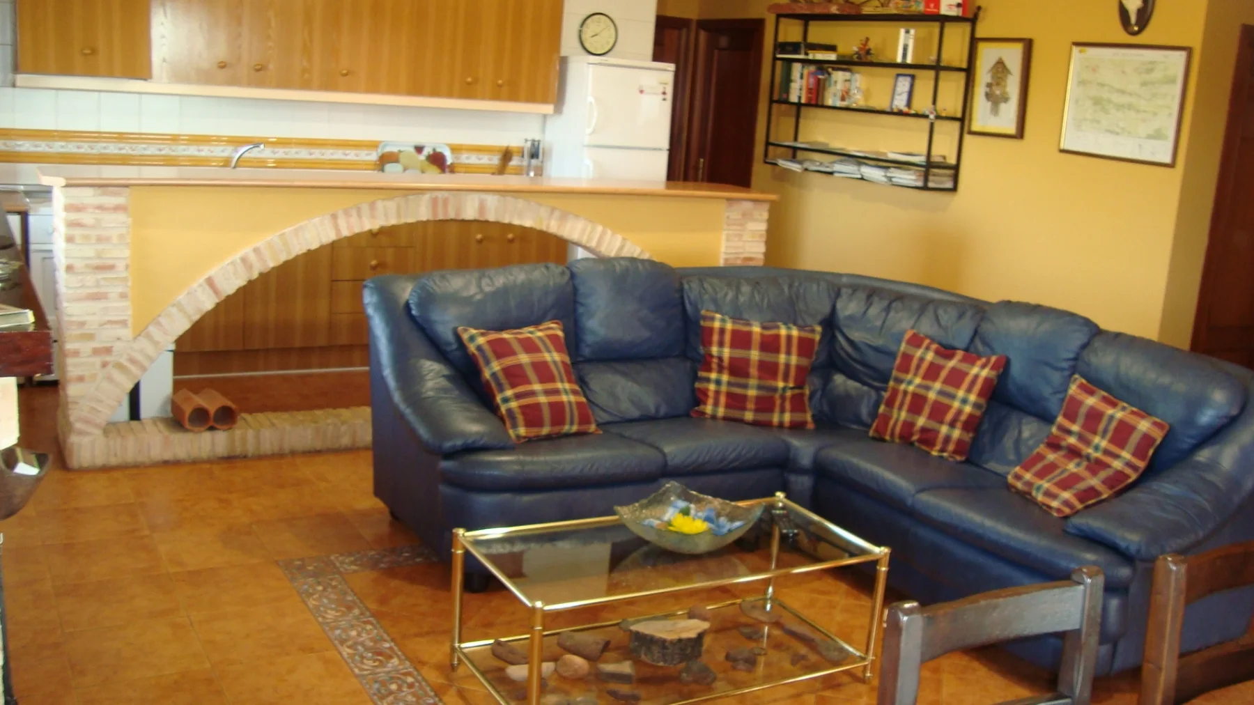 Salón de La Noria Olaya con sofá, chimenea y cocina abierta