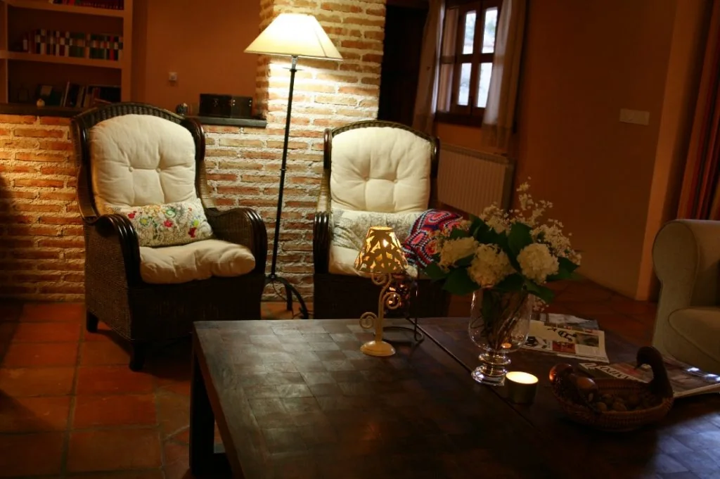 Salón de La Posada del Corralón con chimenea, biblioteca y zona de estar