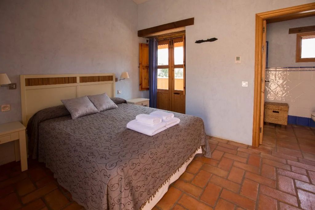 Dormitorio doble de La Posada del Corralón con suelo de barro y mobiliario de madera