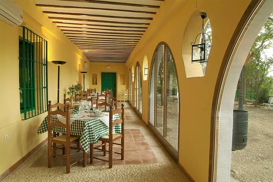 Galería acristalada junto al jardín en Finca Los Cerrillos, Argamasilla de Alba.