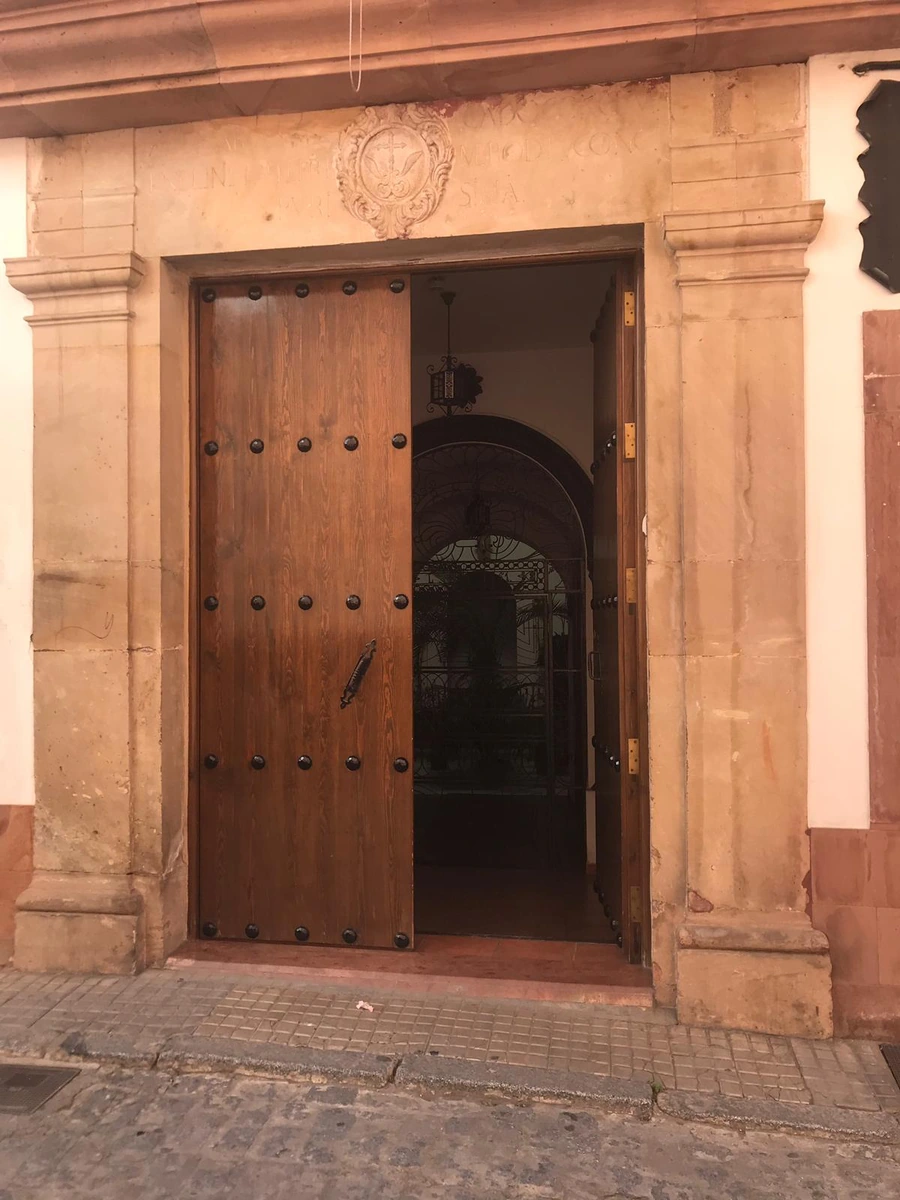 Entrada de Casa Maika con portada de piedra y puerta de madera. · Casa Maika