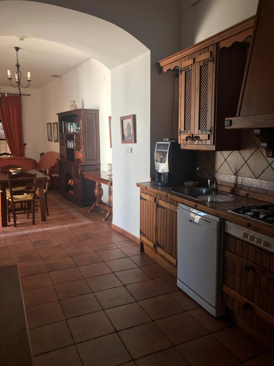 Cocina común con muebles de madera y electrodomésticos. · Casa Maika