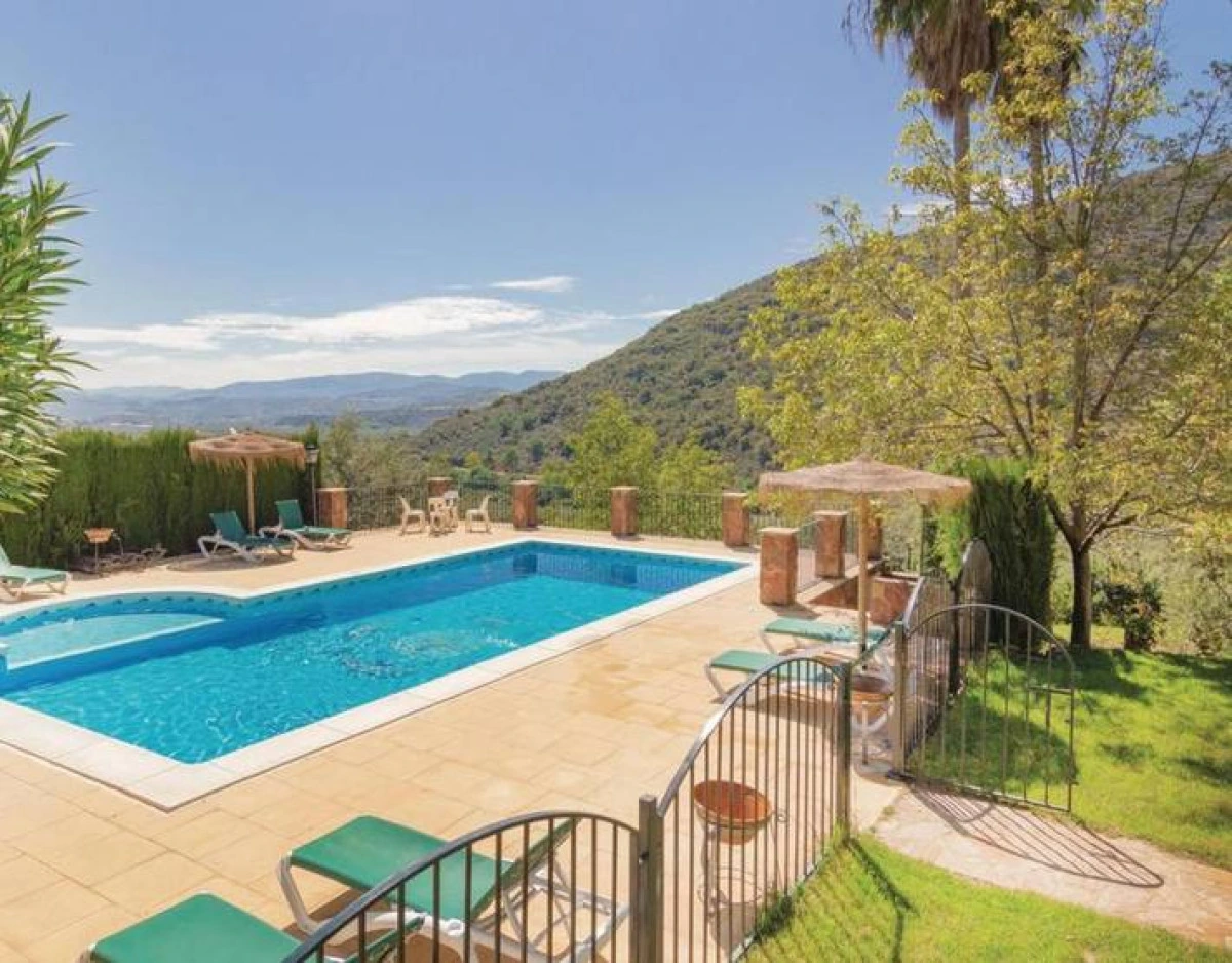 Piscina al aire libre con terraza y vistas a la sierra. · Cortijo La Zamora