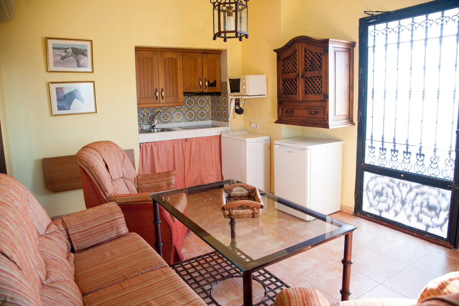 Salón con sofás y cocina abierta de El Mirador. · Cortijo Molino San Juan