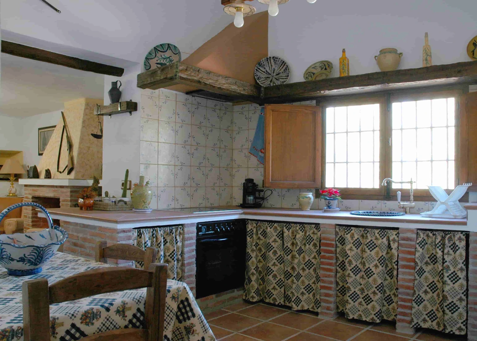 Cocina equipada con azulejos tradicionales, horno y encimeras. · Cortijo Palitroques