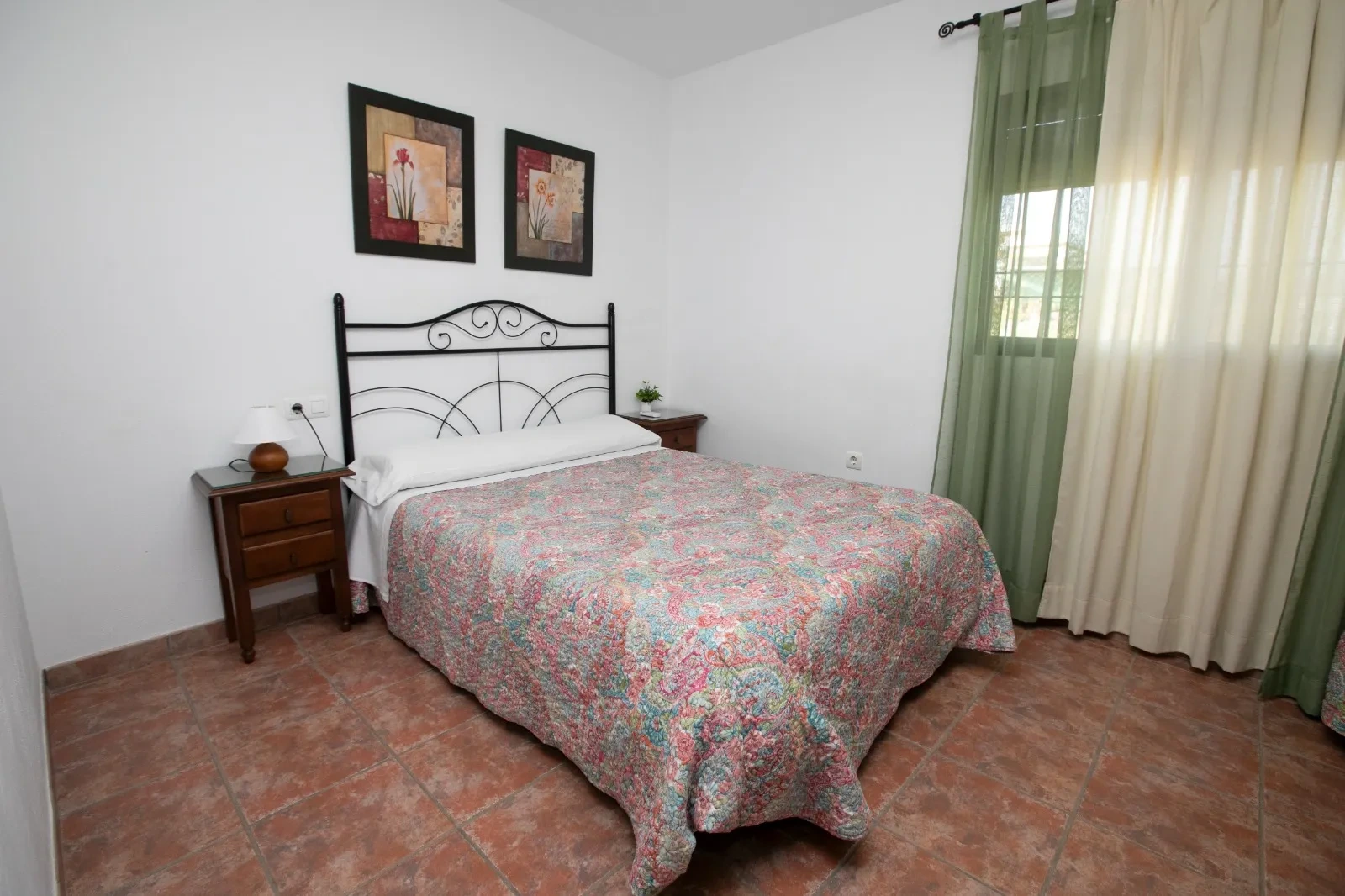 Dormitorio de El Olmo con cama de matrimonio y cabecero de hierro · Casa Rural El Olmo