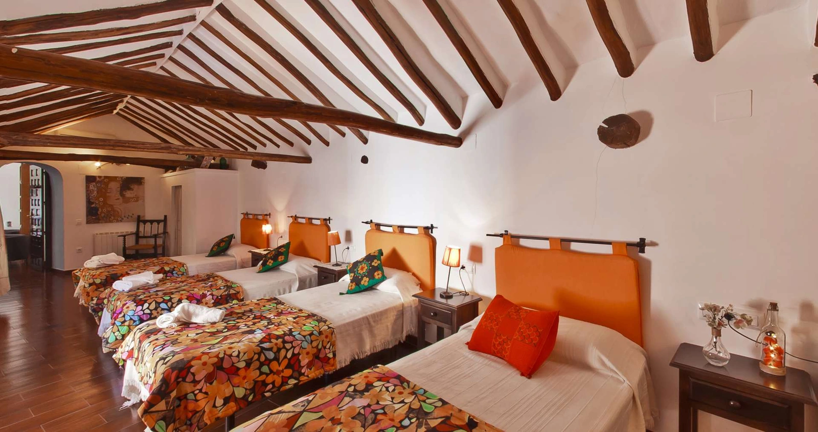 Dormitorio abuhardillado con varias camas individuales. · La Casa de Maita