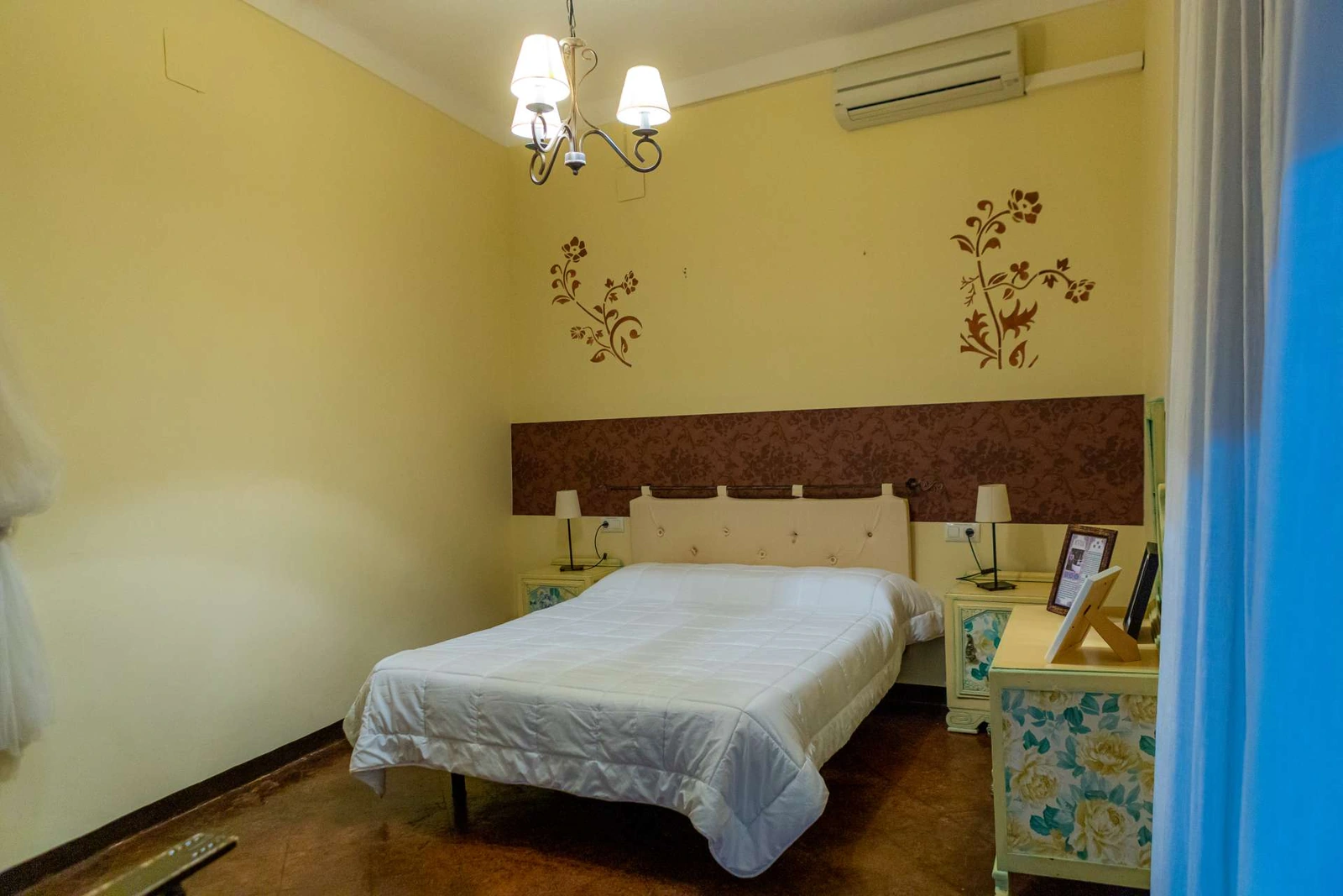 Dormitorio con cama doble y paredes amarillas. · La Casa de Maita