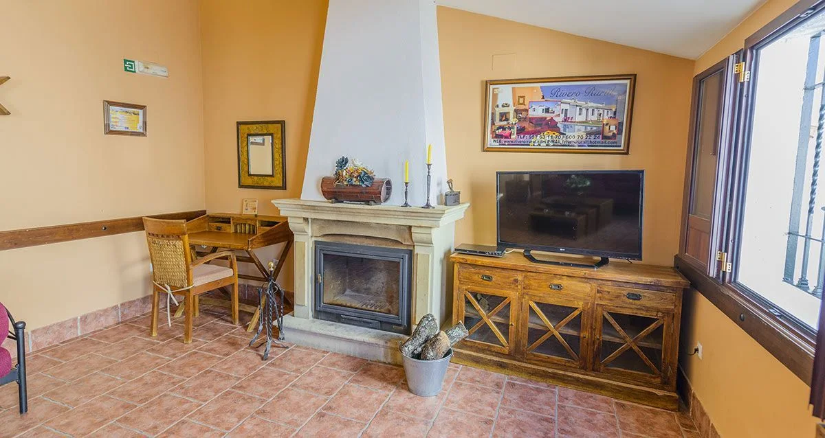 Salón con chimenea y televisión en Rivero Rural