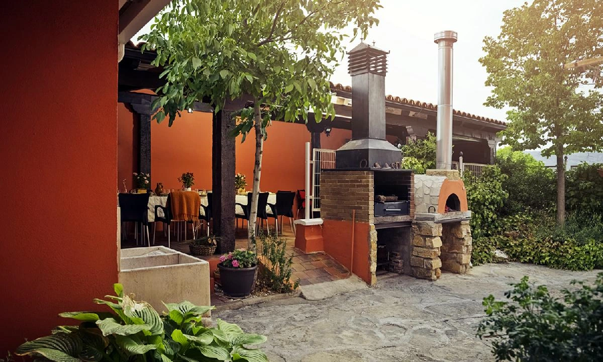 Barbacoa y horno de leña de uso compartido en el patio. · Casa Rural El Sauce