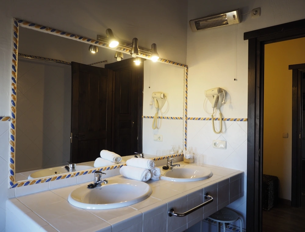 Baño de la habitación El Olivo, con dos lavabos. · La Casa del Villar