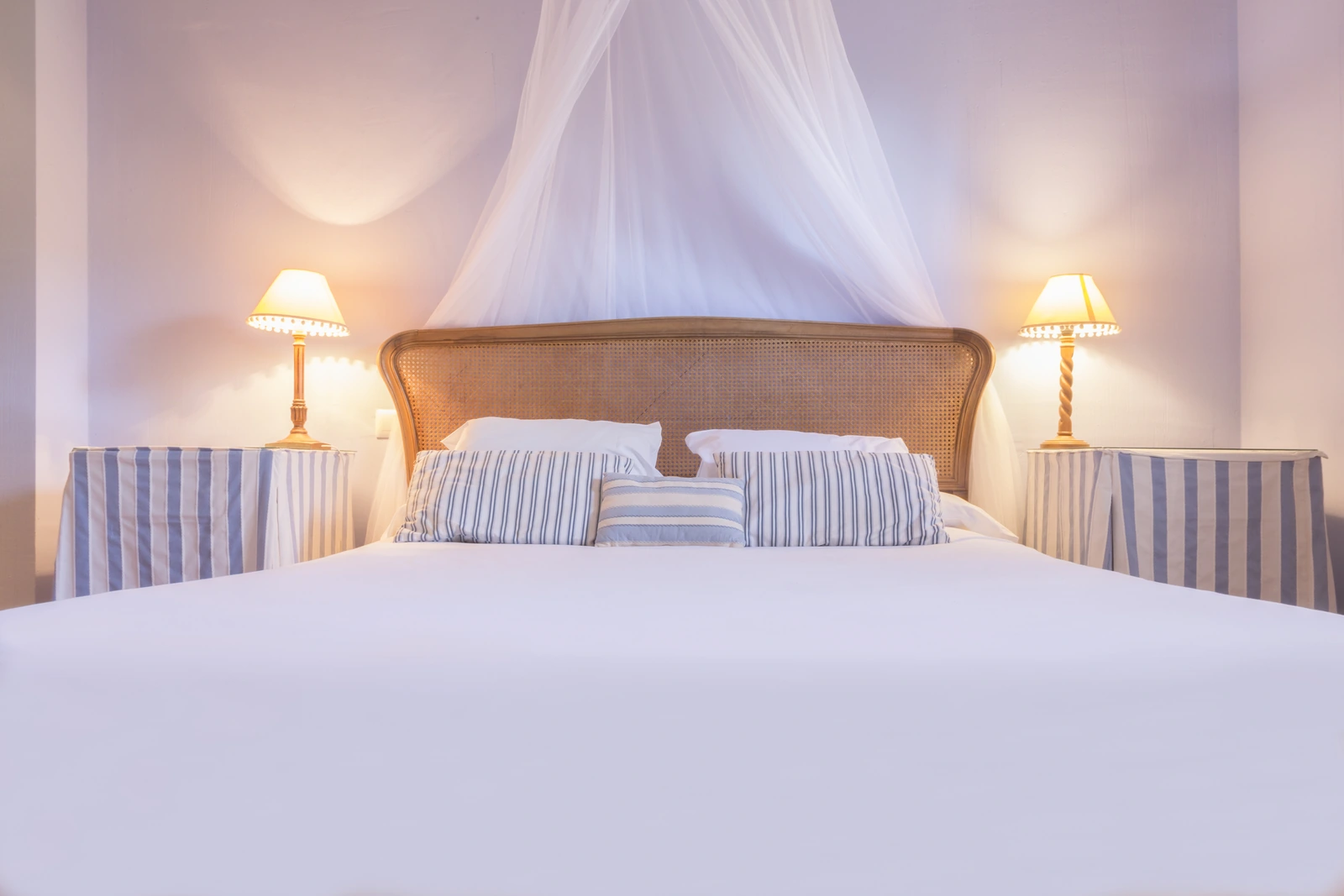 Dormitorio del hotel con cama de madera y dosel de tela blanca. · La Casita de Cabrejas