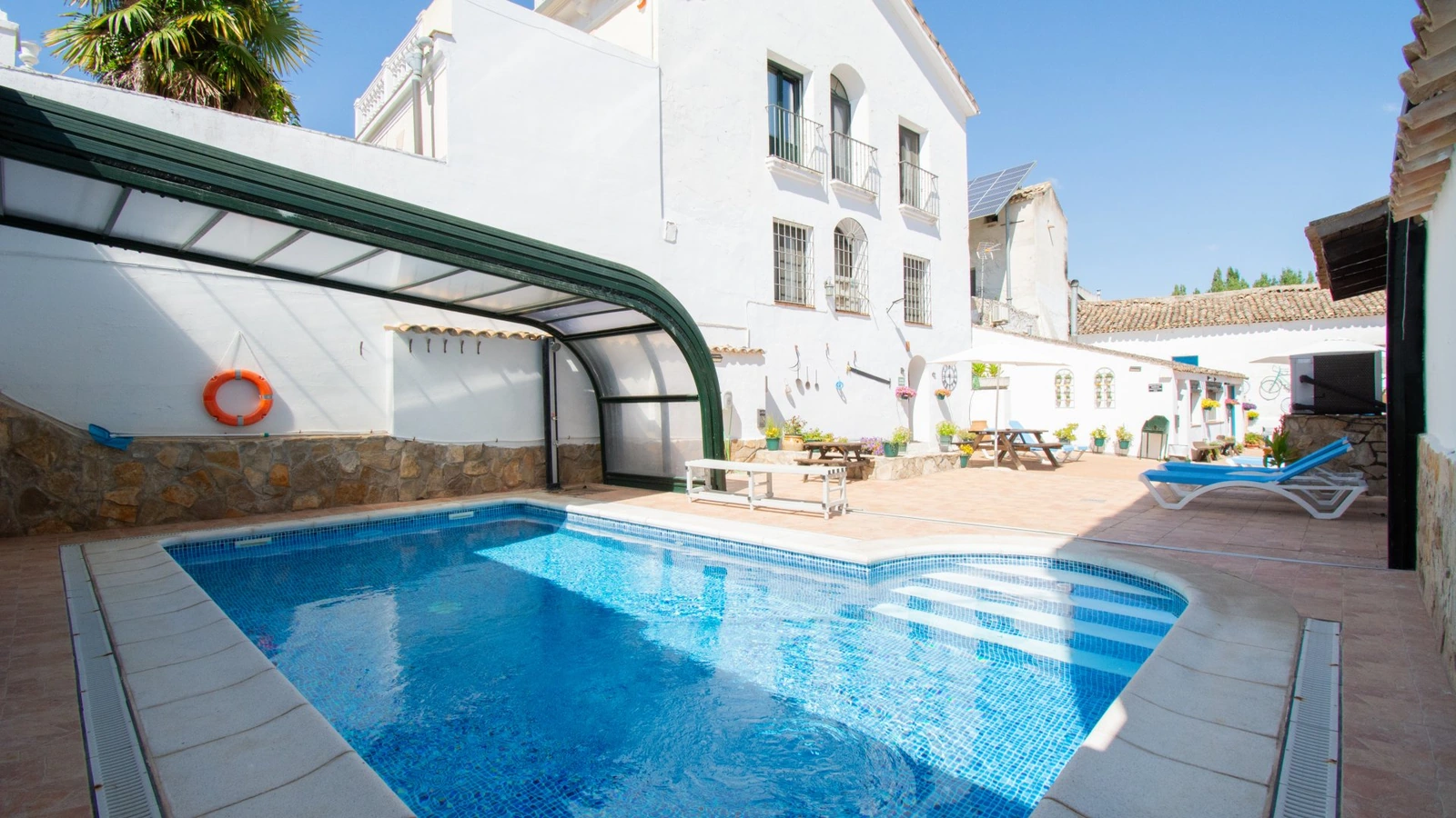 Piscina climatizada con cubierta móvil y edificio al fondo. · Puerta del Agua