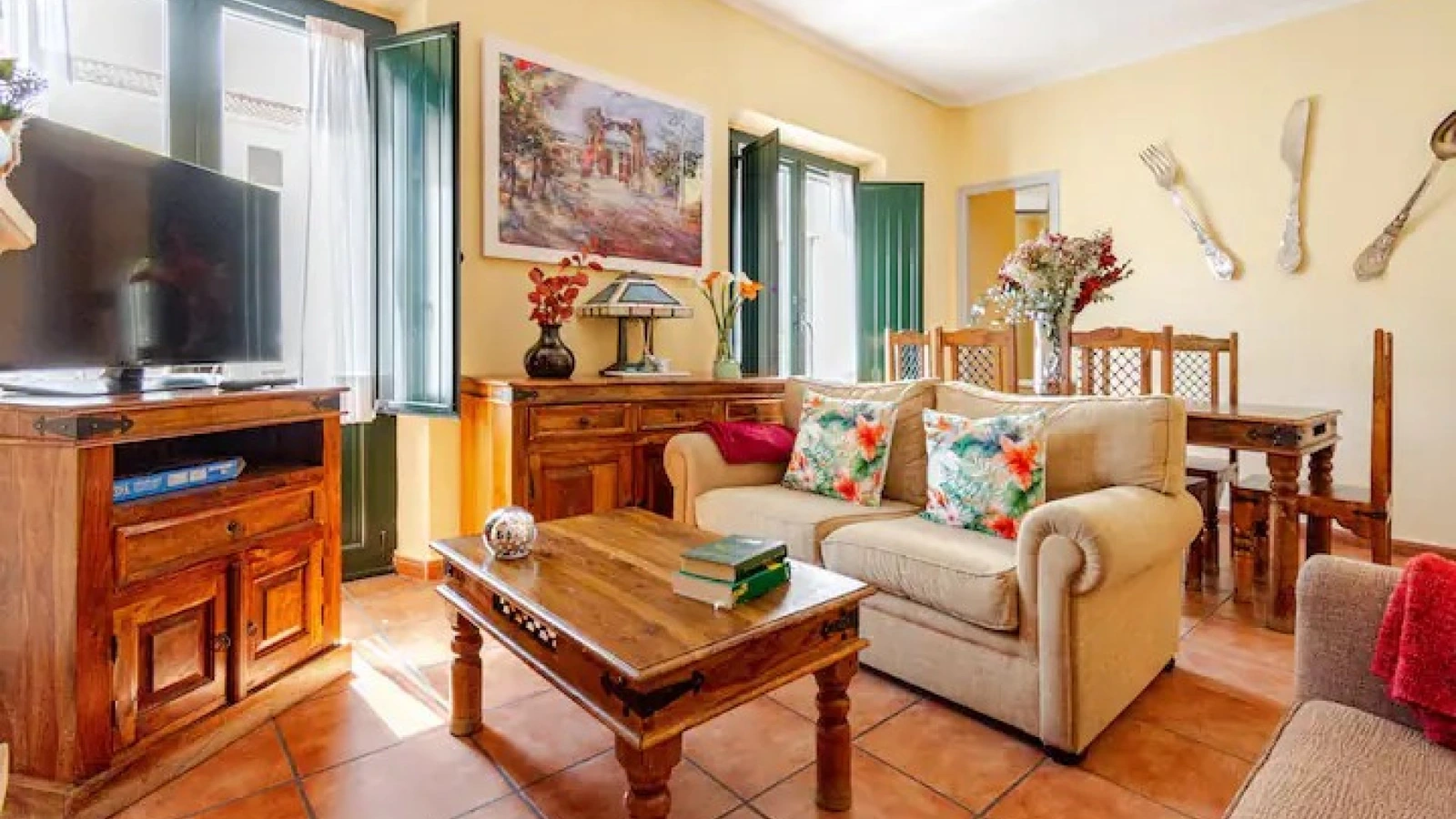 Salón del apartamento El Estanque, con sofás, mesa y mueble de madera. · Puerta del Agua